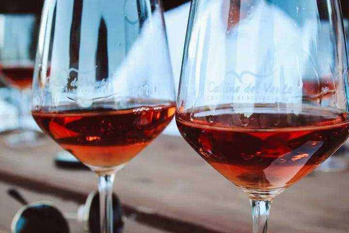 Persone che fanno un brindisi alzando bicchieri di vino durante una celebrazione