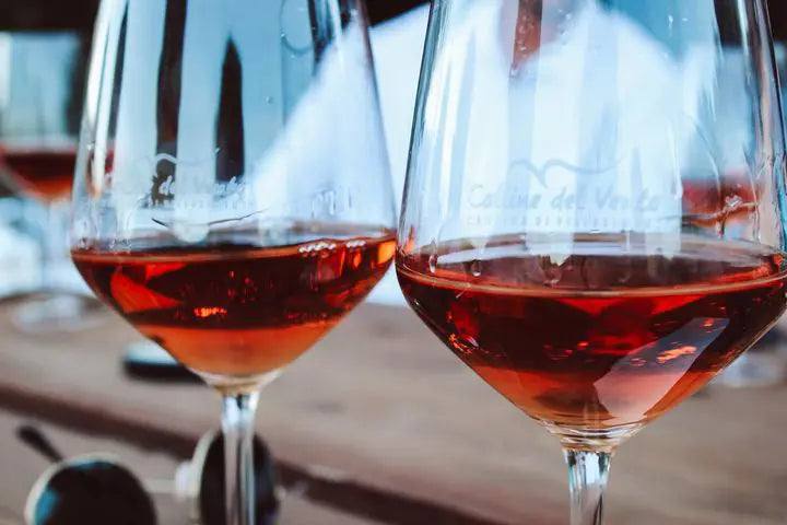 Persone che fanno un brindisi alzando bicchieri di vino durante una celebrazione